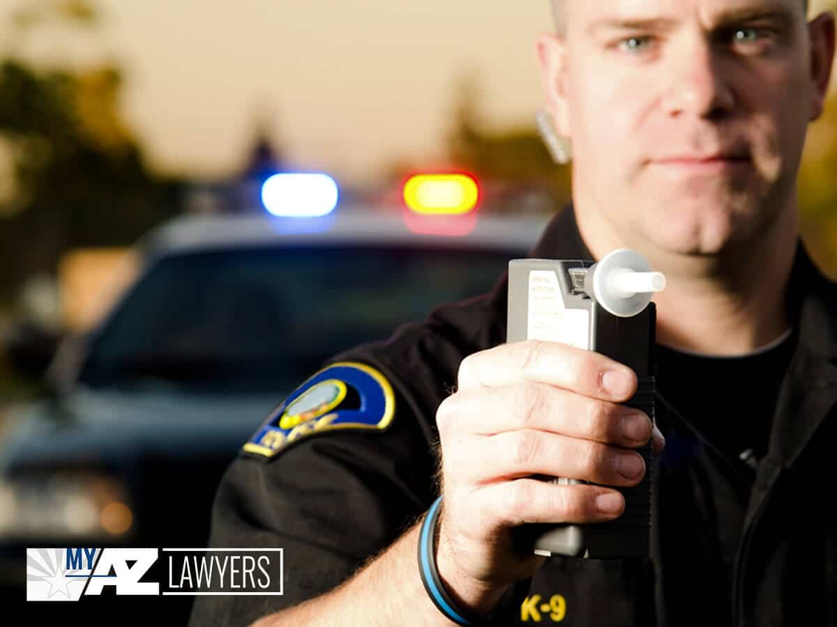 Arizona Police Officer Holding A Breathalyzer Test