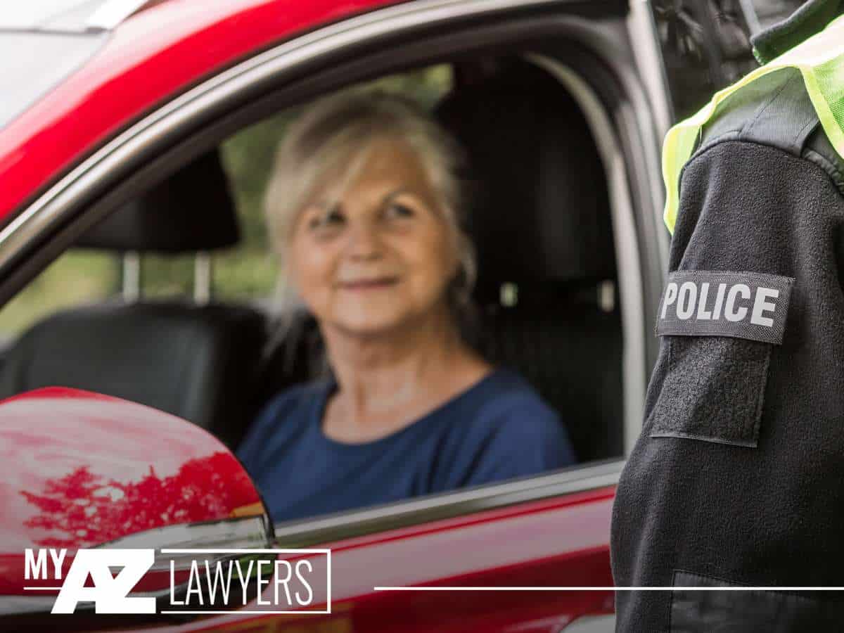 Elderly woman in car stopped by police officer — a scene related to Geriatric DUIs