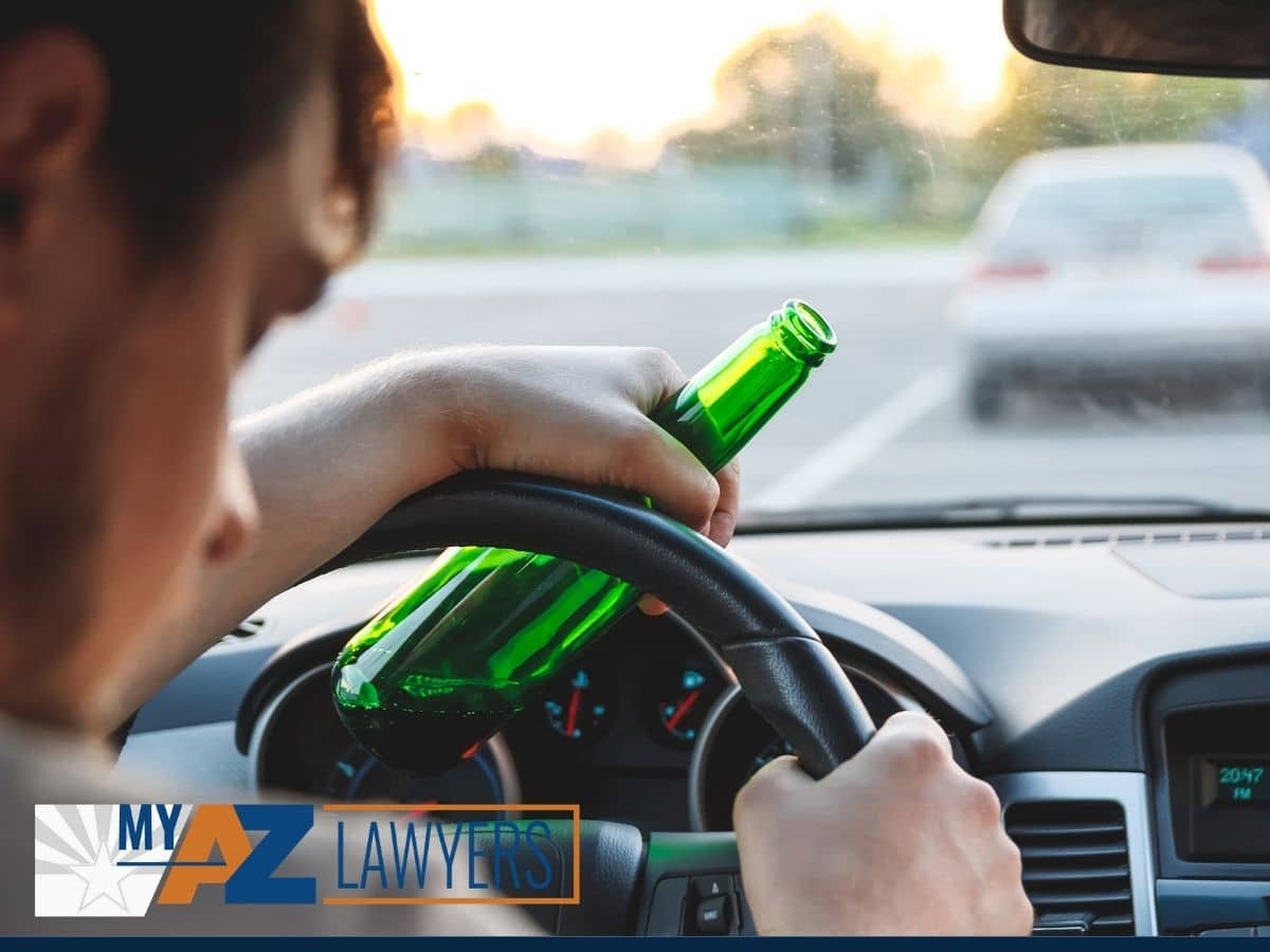 man drinking beer while driving car