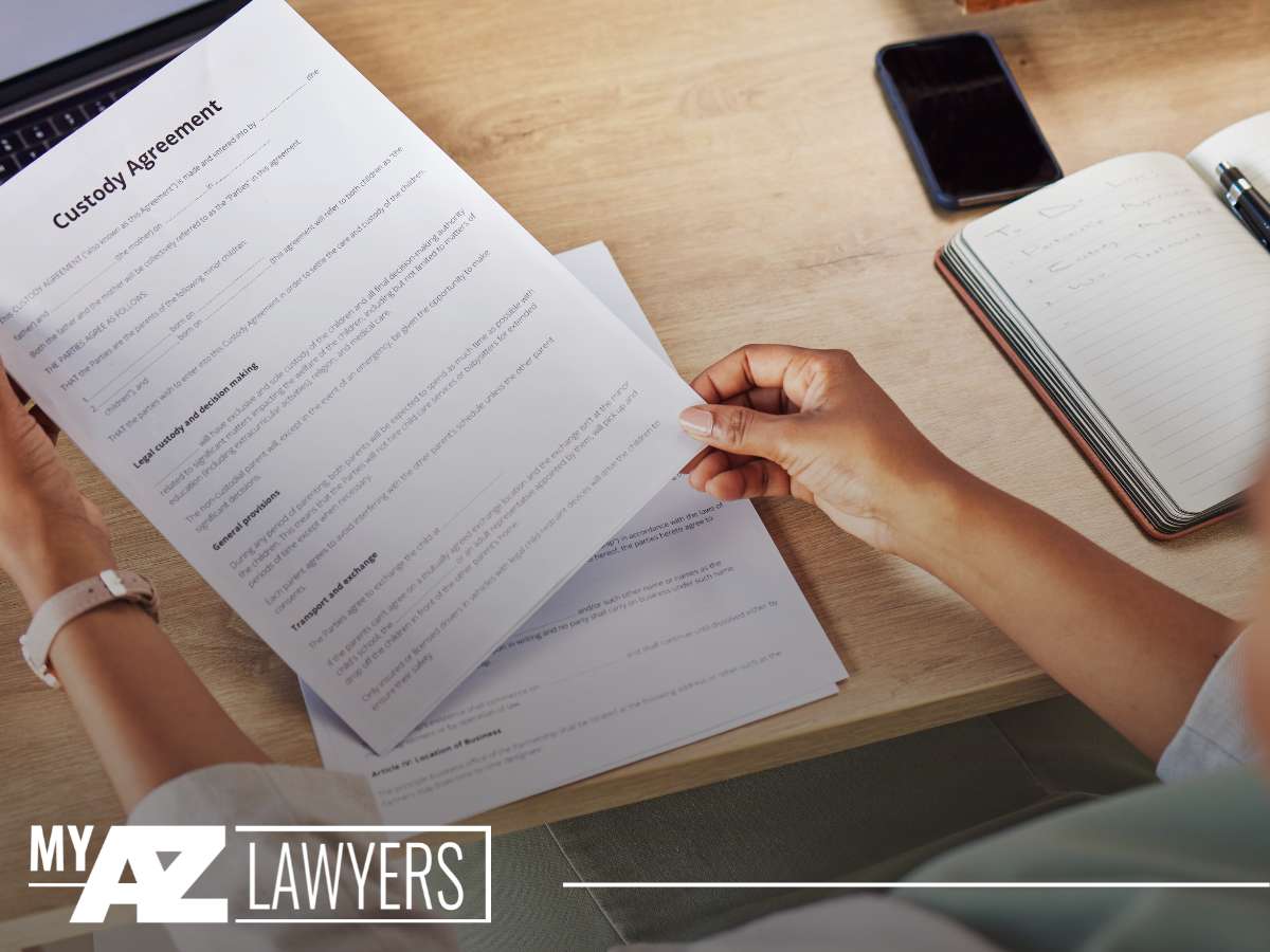 A person reviewing a custody agreement document, indicative of the services provided by an Arizona family law attorney.