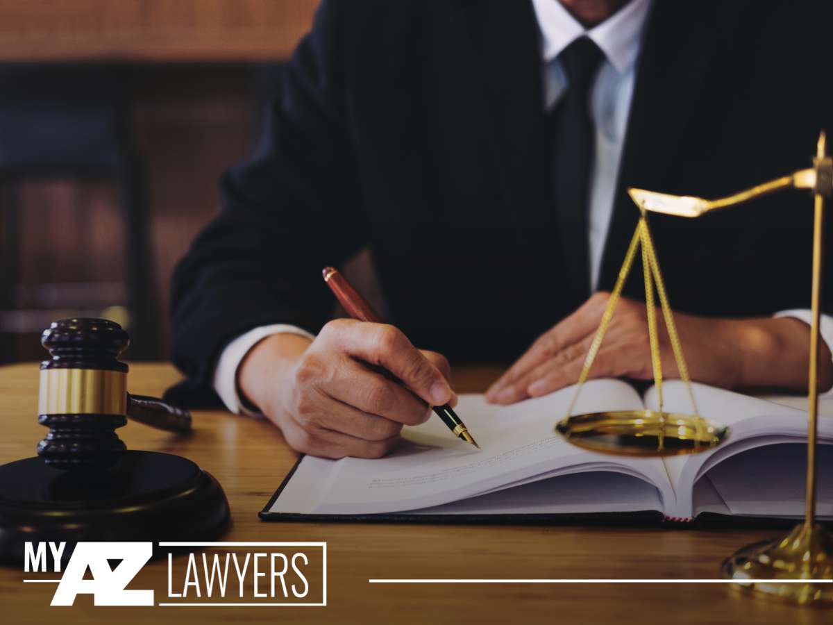 An attorney from My AZ Lawyers signing documents, with scales of justice and a gavel, symbolizing legal assistance for Arizona gig economy workers