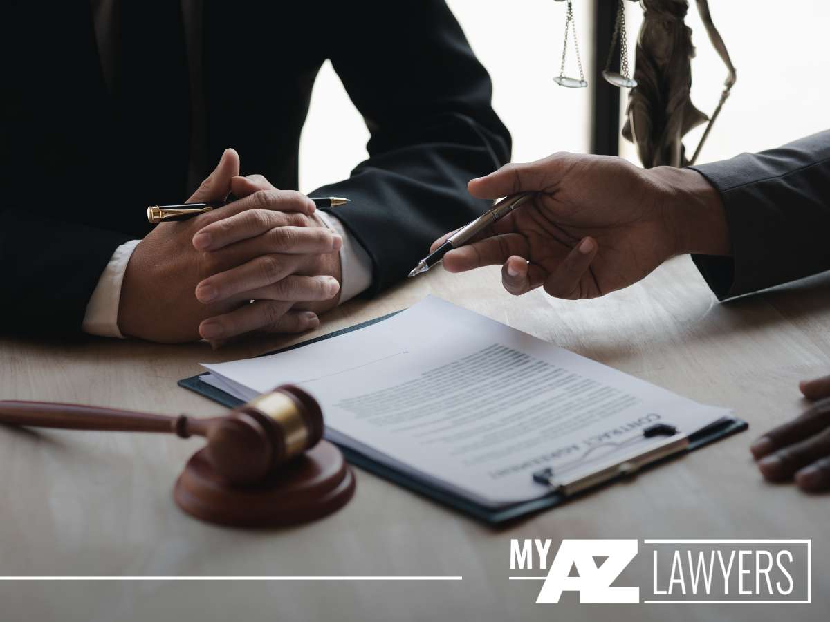 Two lawyers discussing bankruptcy documents at a table, with a gavel in the foreground, in Arizona