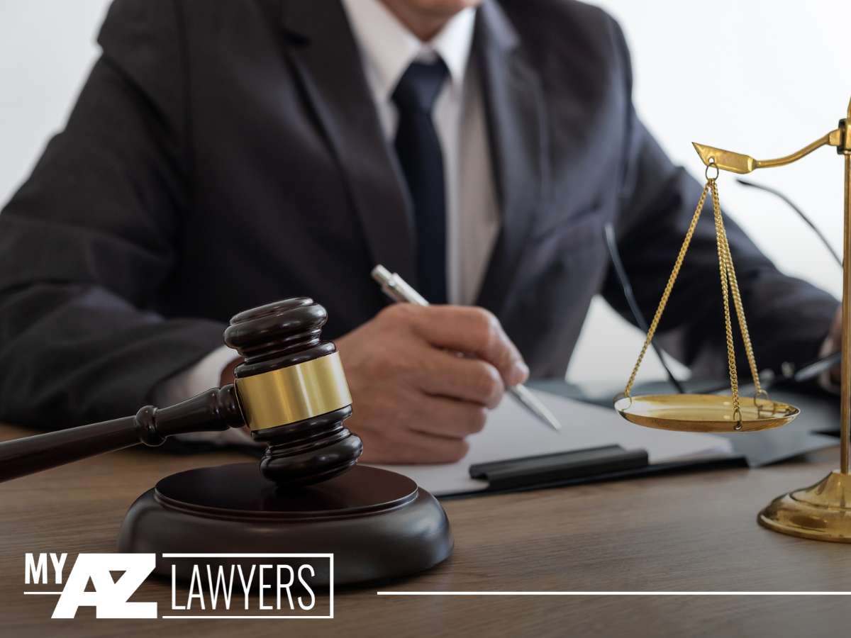 A lawyer writing notes next to a gavel and the scales of justice, representing larceny lawyers at work