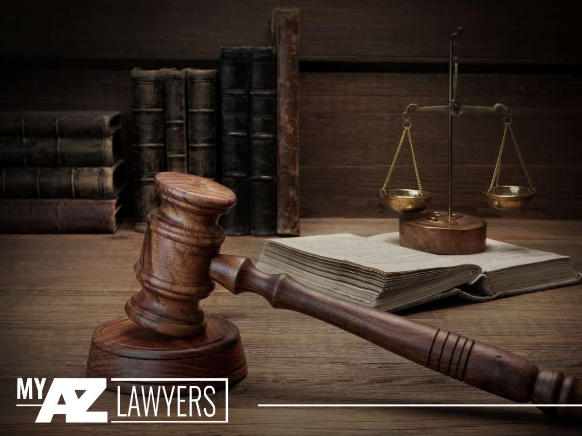 A gavel and scales of justice on a desk with books, symbolizing the work of criminal defense attorneys