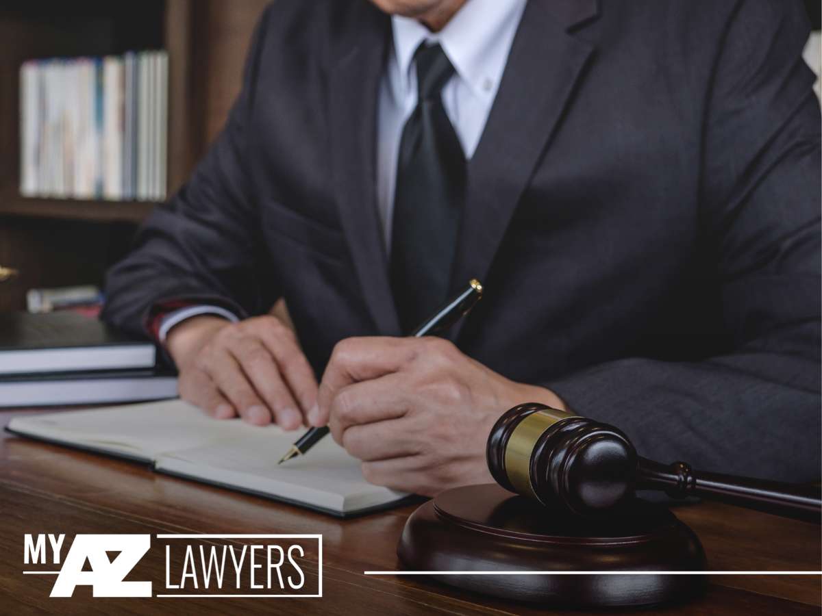 A lawyer writing notes next to a gavel, representing legal services for crypto asset disputes at My AZ Lawyers