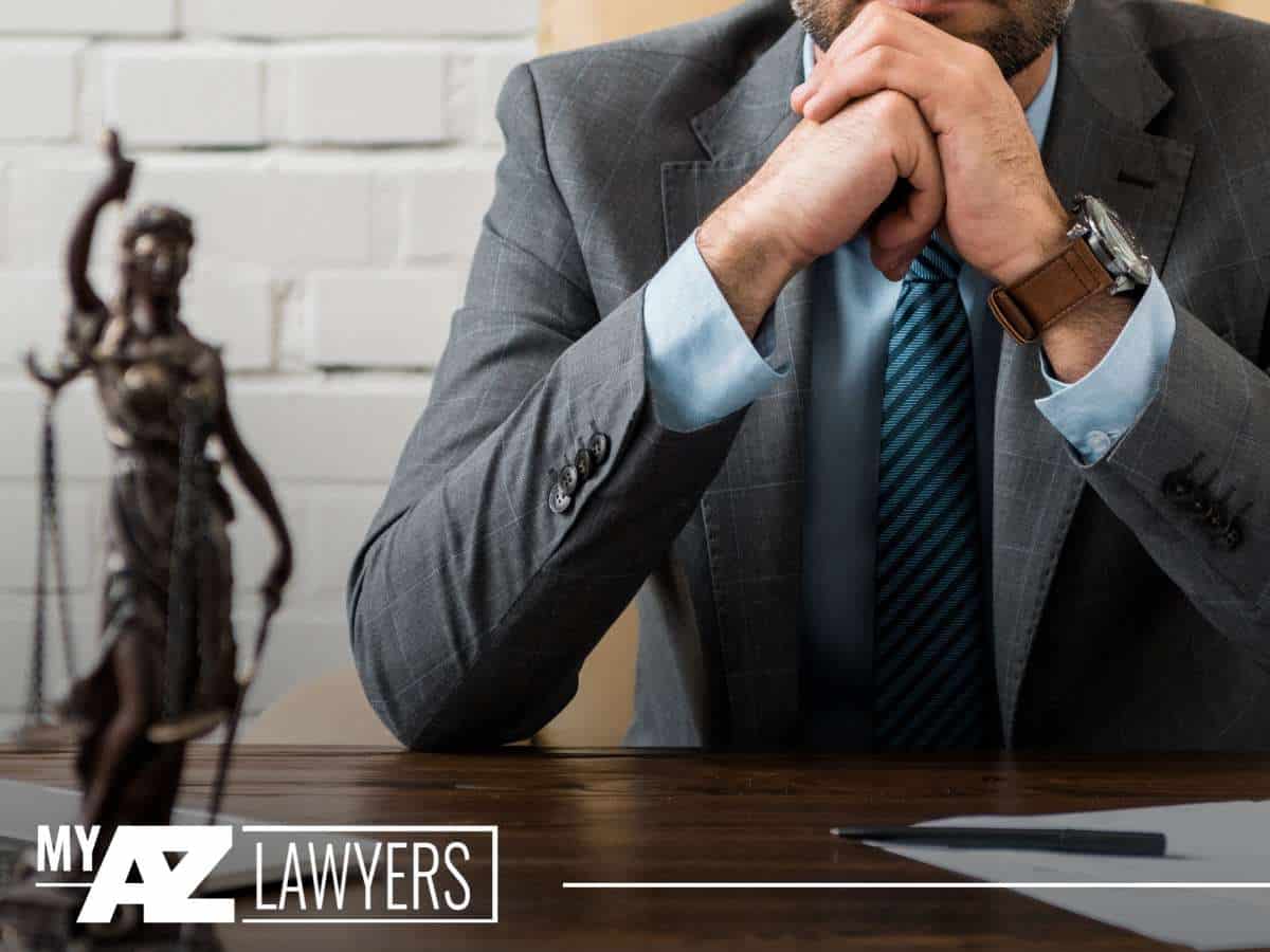 Arizona Drunk Driving attorney consulting on legal strategies with statue of justice in the background